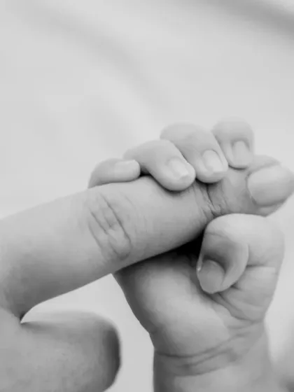 The black and white version of the finger-hold shot, emphasizing the contrast in size and the emotional connection.