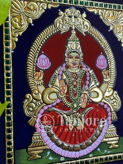 Lakshmi Devi sitting on a lotus, smiling upon us and blessing us all with her glory. The deep blue background makes the gold and colors stand out beautifully.