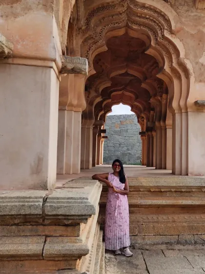 A traveler posing in the beautiful arched corridors of the Lotus Mahal in Hampi.