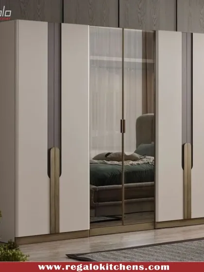 This wardrobe features mirrored central doors that enhance the sense of space in the room. The combination of white and bronze-finish handles offers a contemporary look.