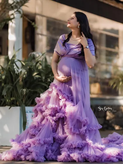 This client looks absolutely radiant, cradling her baby bump in the sunlight. The off-shoulder design of the lavender gown is both elegant and comfortable for a maternity shoot.