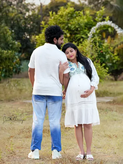 A candid and relaxed outdoor couple portrait. The natural setting and their easy interaction create an authentic and heartwarming image of their journey together.