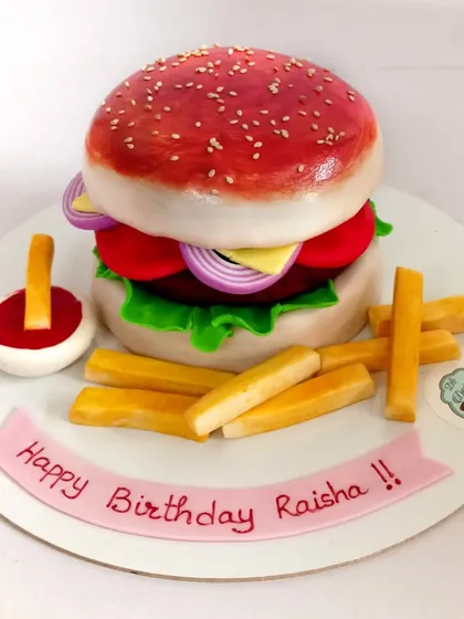 A delicious-looking burger and fries cake, where everything you see is edible. This is one of my favorite types of hyper-realistic cakes to make, perfect for a foodie's fun-themed birthday party.