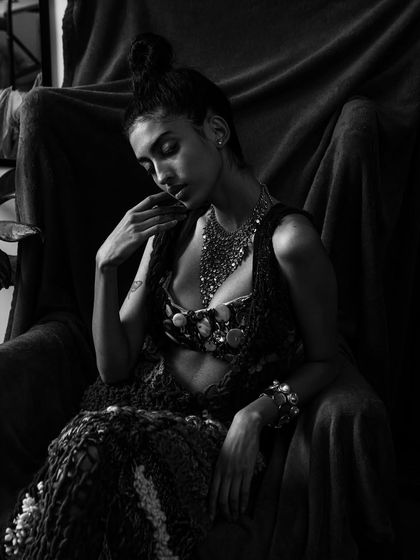 A black and white version of the seated portrait, emphasizing the play of light and shadow on the textures and form.