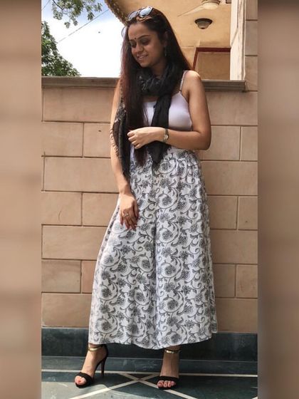 Indian wear can be incredibly comfortable and breezy. These printed palazzo pants paired with a simple white top and a scarf create a chic, modern ethnic look that's perfect for a daytime event or a casual get-together.