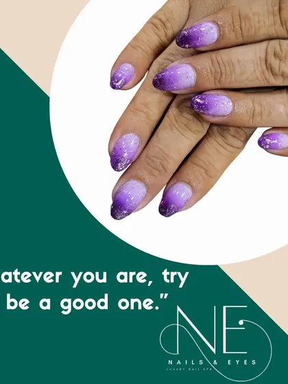 A beautiful purple glitter ombre. The color fades from a light, shimmery lilac to a deep, sparkling violet at the tips.