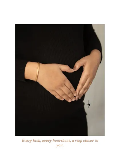 A close-up of hands forming a heart on the baby bump. This simple, iconic gesture is a beautiful and direct expression of love for the little one on the way.