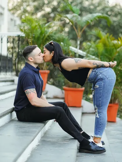 A sweet and playful kiss. This photo, taken on the steps of a building, is full of charm and affection.