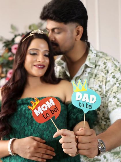 A tender kiss and "Mom to be" and "Dad to be" props make this a perfect announcement photo.