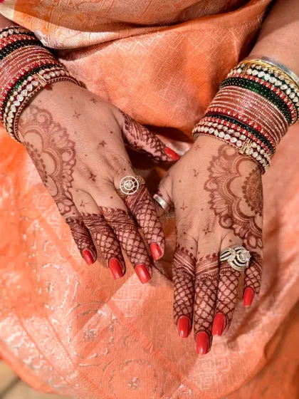 The back of the hands, showing the beautiful color of the mandala designs.