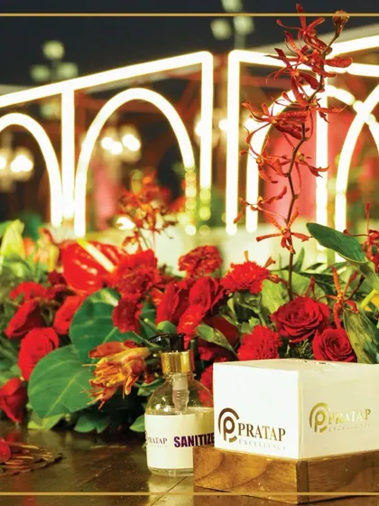 Our branding is subtly integrated into the decor, seen here with custom boxes and sanitizers amidst a lush red floral arrangement, showcasing our attention to every detail.