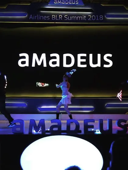 This is a full stage production for the Amadeus Airlines BLR Summit. You can see three of my artists performing a synchronized light show with the Amadeus brand prominently displayed on the stage and screen. I design these shows to integrate seamlessly with your event's staging.