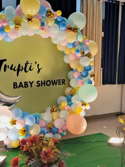 We create dreamy baby showers, like this one for Trupti. This setup includes a custom circular backdrop, a beautiful organic balloon arch in soft pastel colors, and a silver moon foil accent, creating a perfect photo opportunity.