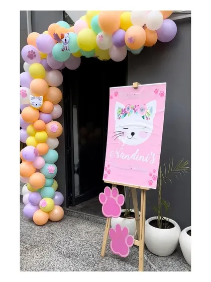 A personalized welcome sign on an easel with a matching balloon garland to greet guests at the entrance of the Marie Cat party.