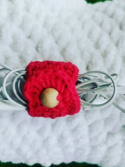 Tired of tangled wires? This cute little red crochet cable organizer is the perfect solution to keep your earphones or charging cables neat and tidy.