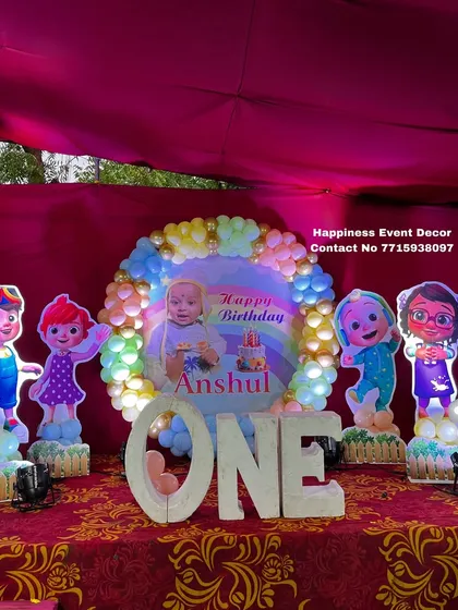 A vibrant Cocomelon themed stage for a first birthday party. This setup includes character cutouts, a custom backdrop with the child's photo, and large 'ONE' letters for the perfect photo opportunity.