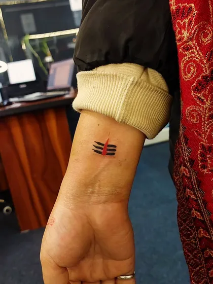 A minimalist representation of Lord Shiva's Tripundra tilak on the wrist. This small tattoo is a subtle yet powerful expression of devotion.