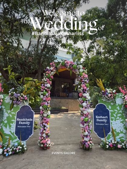 A beautiful floral archway serves as the main entrance to the wedding, with signs welcoming the two families. It's a warm gesture that symbolizes the union of not just the couple, but their loved ones as well.