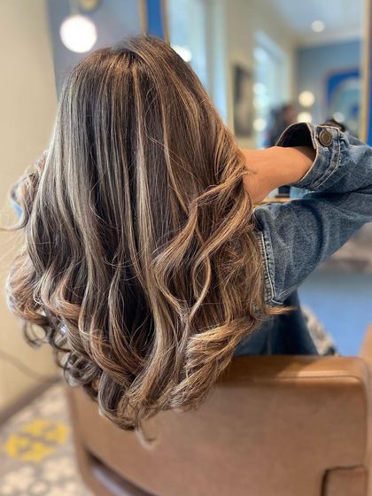 A stunning balayage with a mix of cool blonde and warm caramel tones. This combination creates a beautiful, high-contrast look on long, wavy hair.