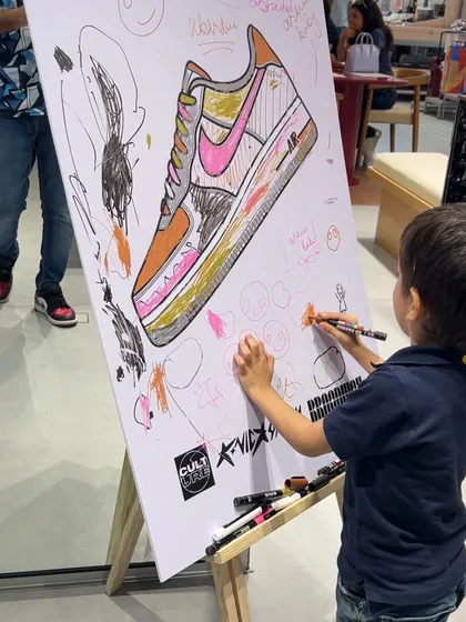 Our events are for everyone. Here, a young guest adds his own creative touch to our large collaborative art canvas, a feature we include to make our activations truly interactive and family-friendly.