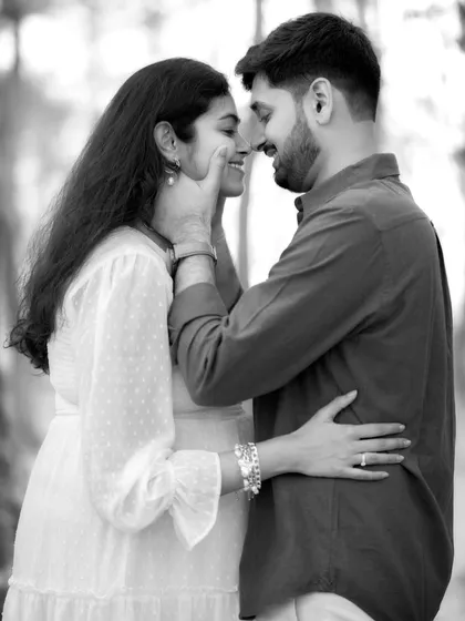 A quiet, intimate moment captured in timeless black and white. This close-up focuses on the tender connection between the couple, showcasing the love and support that surrounds their journey to parenthood.