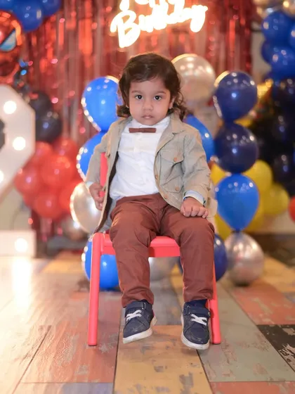The birthday boy sitting confidently, ready for his Spiderman party to begin.