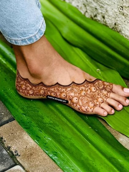 Another angle of the full-coverage foot mehandi, showing the clean scalloped border and the fine details of the pattern.
