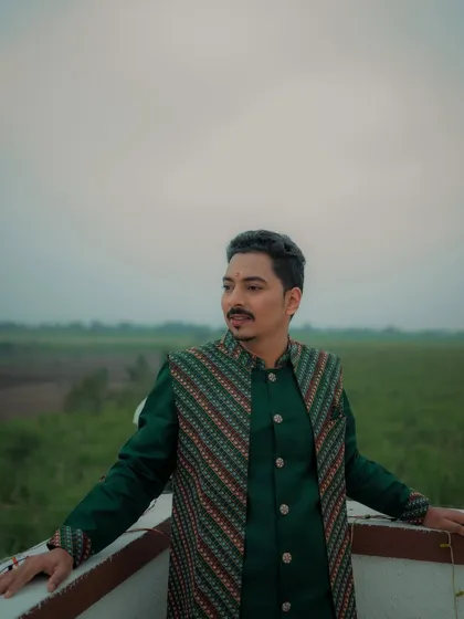 A stylish portrait of the groom during his Haldi ceremony. The open sky and natural landscape in the background add a dramatic and expansive feel to the shot.