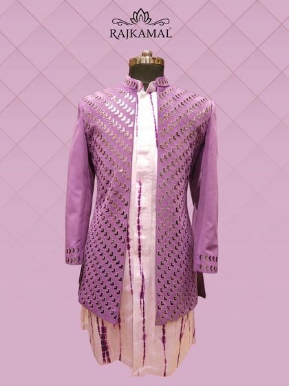 A modern Indo-Western outfit in a vibrant purple, featuring a jacket with geometric cut-out details and a tie-dye inner kurta.