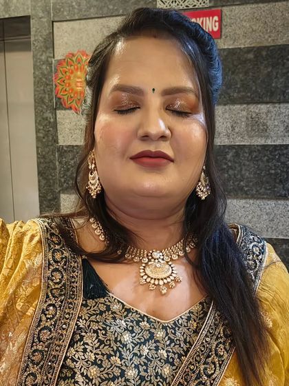 Golden hour glow. This HD party makeup features a warm, shimmery eye look that complements her yellow and green outfit.