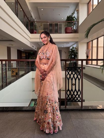 A full-length shot of the bride in her beautiful floral embroidered outfit for her Haldi. The soft makeup and half-up hairstyle complete the look.