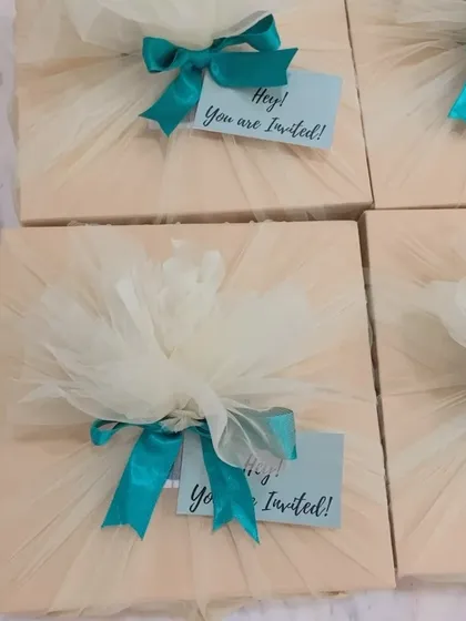 A simple and sweet invitation hamper. This gift box is elegantly wrapped in soft tulle with a vibrant teal ribbon, finished with a cheerful 'Hey! You are Invited!' tag.