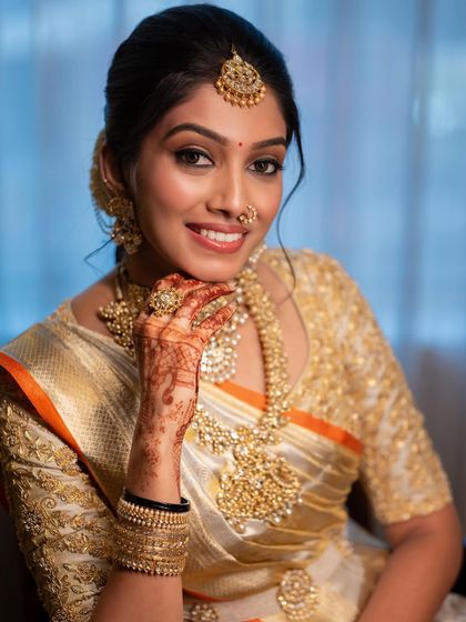 A beautiful close-up of our bride Hima, showcasing her flawless makeup and the intricate embroidery of her custom gold blouse.