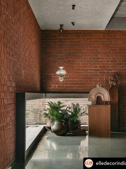 A glimpse from an upper level shows how greenery is integrated into every part of the architecture. Potted ferns are placed to be seen from multiple vantage points, making the connection to the outdoors feel constant and layered.