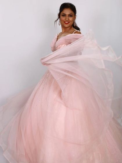 A playful moment with the flowing tulle skirt of the pink ball gown. These dresses are made for twirling and celebrating.