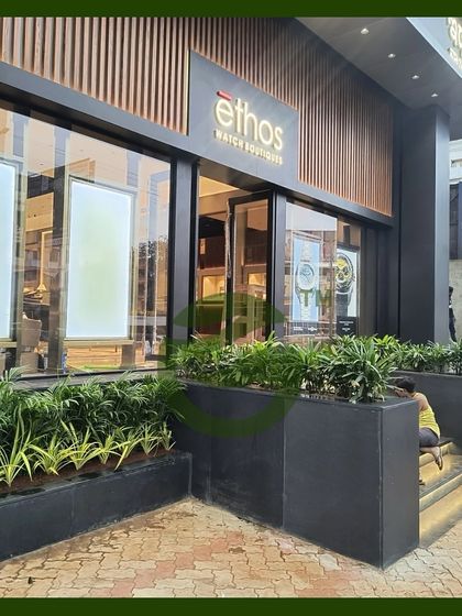 A touch of green can completely transform a commercial entrance. For the Ethos watch boutique, we designed and installed these sleek, modern planters filled with lush foliage to create a welcoming and sophisticated entryway that reflects the brand's elegance.