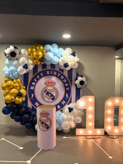 A detailed look at the Real Madrid 10th birthday setup, focusing on the balloon crest and the light-up numbers.