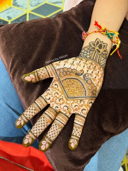 A simple and elegant design with a peacock and lotus on the back of the hand.