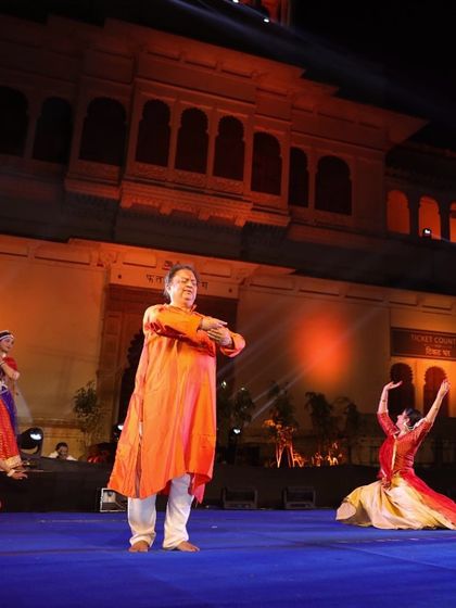 Pt. Jai Kishan Maharaj directing the dancers on stage during the Meera Mahotsav. Our service includes complete creative direction to ensure the performance is impactful and authentic.
