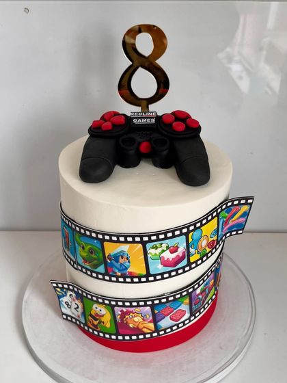 Level up your celebration with this gamer-themed cake. It's topped with an edible game controller and wrapped in a film strip of popular game icons, making it the perfect cake for a young gamer's eighth birthday.