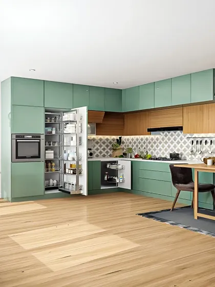 This spacious L-shaped modular kitchen is designed for both beauty and efficiency. It combines a refreshing sage green finish with warm wood tones, a patterned backsplash, and a fully integrated pantry unit for maximum storage.