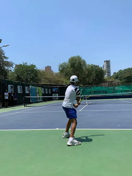 A player prepares to hit a forehand during a sunny day match at the TenniStation Season 12 tournament.