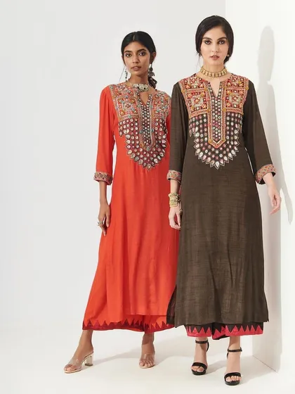 Two models in elegant, embroidered kurtas. Their makeup is clean and sophisticated, with a focus on flawless skin and a neutral color palette that allows the intricate outfits to shine.