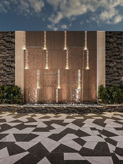 A detailed shot of the water wall, which features cascading streams of water illuminated by integrated lights. The combination of rough stone and smooth metal creates a beautiful textural contrast.