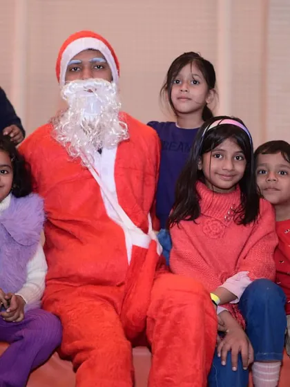A group of children posing with our Santa Claus during the Christmas carnival.