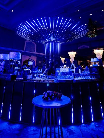 The central bar, glowing with blue LED lights, serves as a vibrant hub for the Sangeet party.