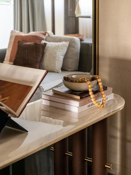 Corners are a canvas for personal expression. Here, stacked books, a ceramic bowl, and amber beads transform a simple console into a curated corner, layering textures and personal touches.