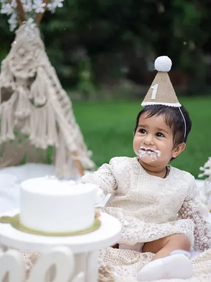 A first birthday is a memory to treasure forever. This little girl is enjoying her cake during a boho-themed picnic shoot in our garden. We provide everything, from the beautiful lace dress to the props, to make it perfect.