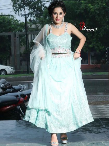 A full-length view of the light sea-green lehenga. The layered skirt adds volume and movement, making it a fun and flirty option.