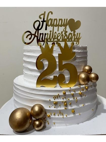 A grand 25th-anniversary cake in a two-tier design. This Nutella truffle cake is decorated with golden spheres and a custom "25" topper for a milestone celebration.